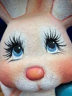 a close up of a stuffed animal with blue eyes and long eyelashes on it's face