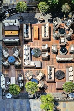 an overhead view of a patio with lots of furniture and trees in the back ground