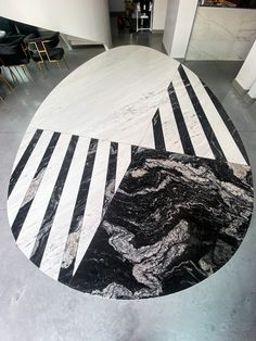 a black and white marble table in the middle of a room with chairs around it