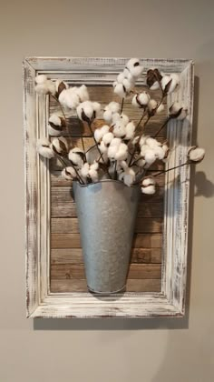 a vase filled with cotton sitting on top of a wall