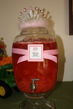 a glass jar filled with red liquid on top of a table