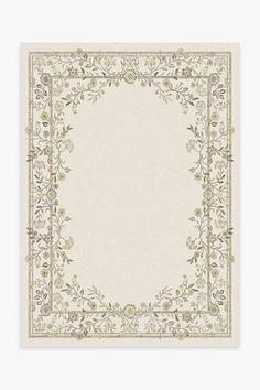 a beige and white rug with an ornate border on the bottom, surrounded by leaves