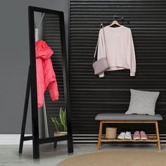 a coat rack, mirror and bench in a room