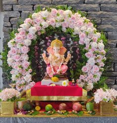 an altar decorated with flowers and a gandap in the middle, surrounded by pink roses