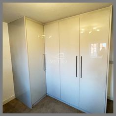 an empty room with white cupboards and glass doors