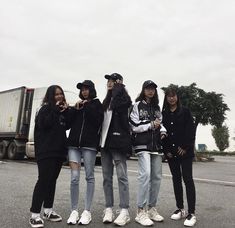 four girls standing in the middle of an empty parking lot