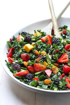 a white bowl filled with fruit and greens