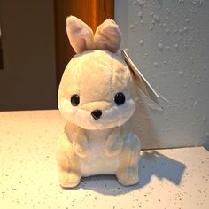 a white stuffed animal with a pair of scissors in it's ear sitting on a counter