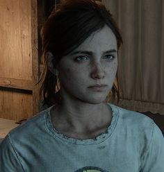 a woman with freckles on her face standing in front of a wooden door