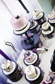 a table topped with lots of cakes and cupcakes on top of each other