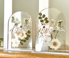 two clear vases with flowers and the word love on them