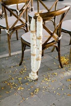 the chairs are decorated with white flowers and twine