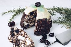 a piece of cake sitting on top of a white plate next to berries and a knife