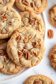 a plate full of cookies with pecans on top