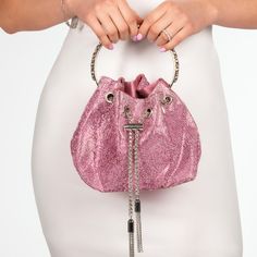 a woman is holding a pink purse with chains on the handle and it's inside