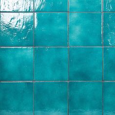 a blue tiled wall with white grouting