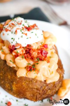 a baked potato with macaroni and cheese on it, topped with sour cream