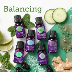 an assortment of essential oils on a table with sliced cucumbers, mints and leaves