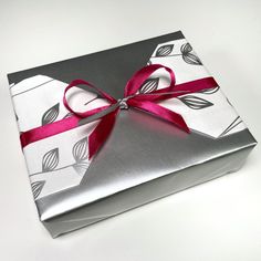 a present wrapped in silver and pink ribbon