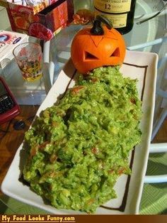 a white plate topped with guacamole and a jack - o'- lantern