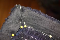 a piece of fabric with some yellow pins on it