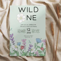 a wild one birthday party with flowers and plants on the front, along with an information card