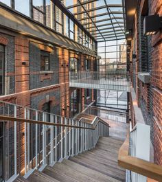 an indoor area with wooden floors and brick walls, along with glass windows that overlook the city