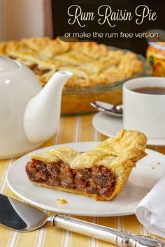 a piece of pie sitting on top of a white plate next to a cup of tea