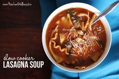 a bowl of lasagna soup on a blue napkin with the title slow cooker lasagna soup