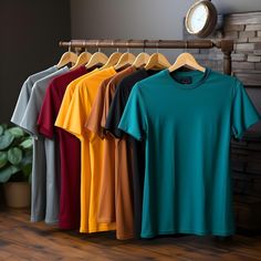 there are many different colored shirts hanging on the clothes rack in front of a clock