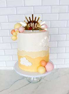 there is a cake that has been decorated with clouds and sun on the top one