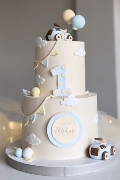 a three tiered cake with cars and clouds on it