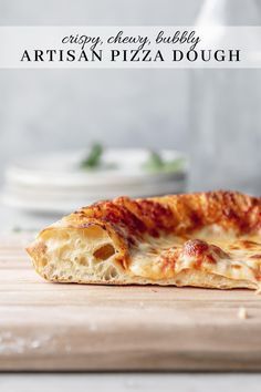 a piece of pizza sitting on top of a wooden cutting board next to a bottle of wine