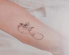 a woman's arm with a flower tattoo on the left side of her leg