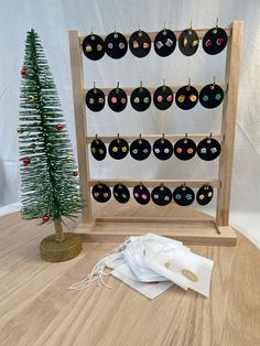 a small christmas tree is next to an ornament with black cats on it