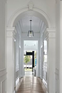 an empty hallway with white walls and wood floors