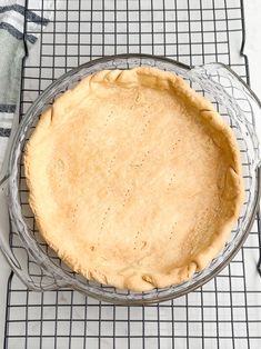 an uncooked pie sitting on top of a cooling rack next to a towel