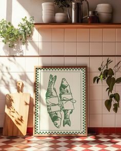 a kitchen counter with a cutting board, potted plants and a framed print on the wall