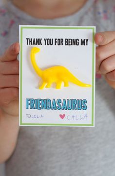 a person holding up a card with a yellow dinosaur on it