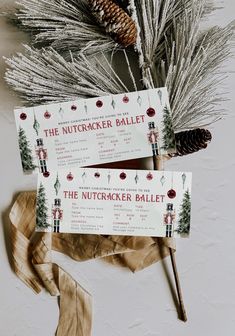 two tickets sitting on top of each other next to pine cones and evergreen branches with the words nutcracker ballet written on them