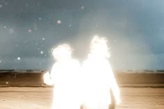 two people walking on the beach at night