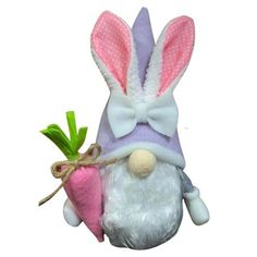 a stuffed bunny with a carrot in it's mouth and wearing a pink hat