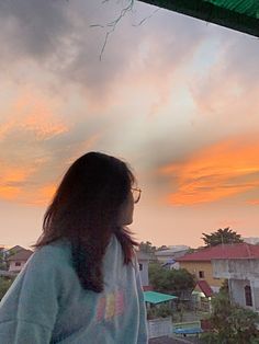 a woman standing on top of a roof looking at the sky