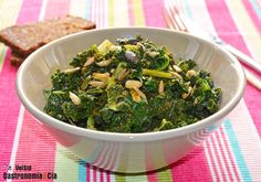 a white bowl filled with broccoli and nuts on top of a colorful table cloth