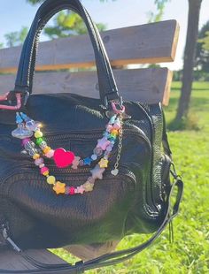 a black purse sitting on top of a wooden bench