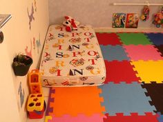 a child's room with colorful floor tiles and toys on the floor, including a bed