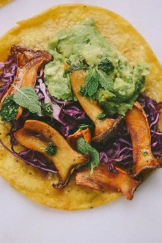 a tortilla topped with vegetables and guacamole