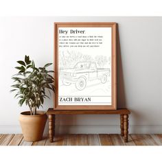 a poster on a wooden table next to a potted plant and a wall with a quote about hey driver