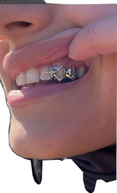 a close up of a person's teeth with braces and piercings on them