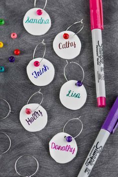 some personalized name tags are on a table next to a marker and pen with markers